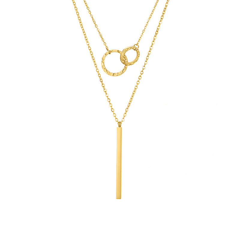 un collier en or avec une longue barre dessus