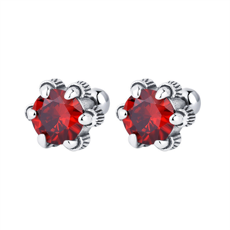 une paire de boucles d'oreilles en cristal rouge sur un fond blanc