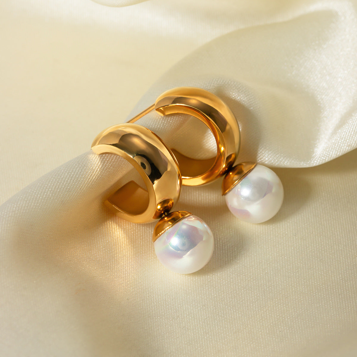 un gros plan d'une paire de boucles d'oreilles sur un tissu blanc