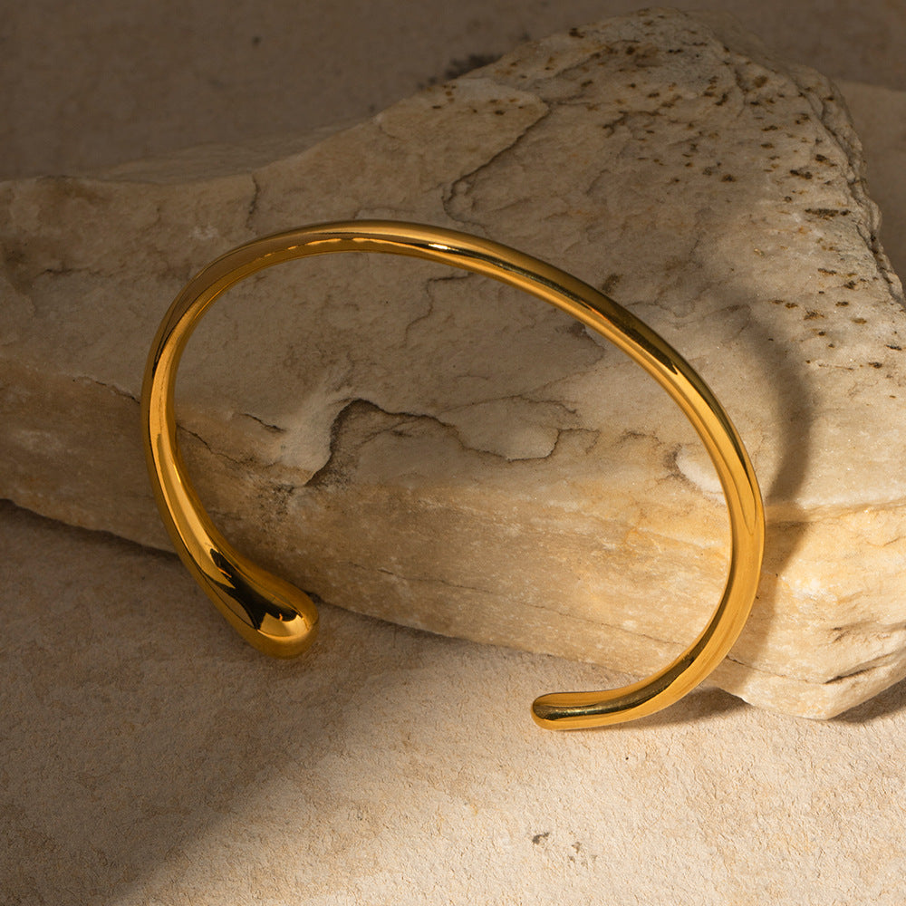 un gros plan d'un bracelet en or sur un rocher
