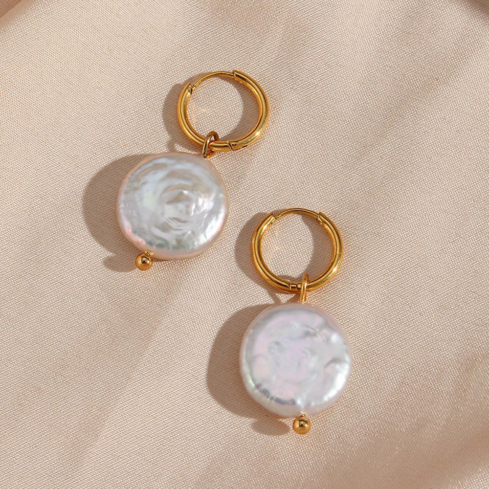 une paire de boucles d'oreilles avec une perle suspendue