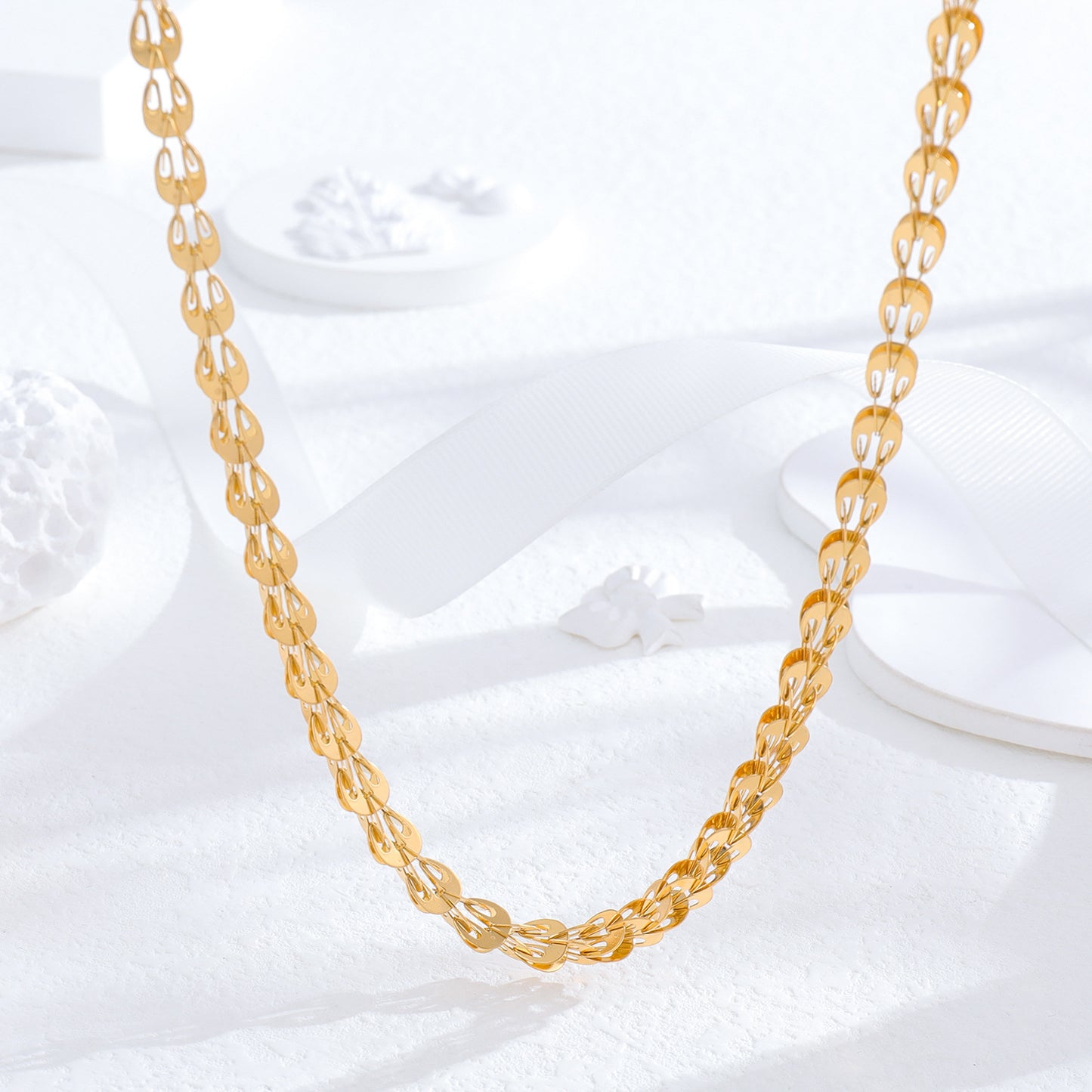 un collier en or sur une surface blanche