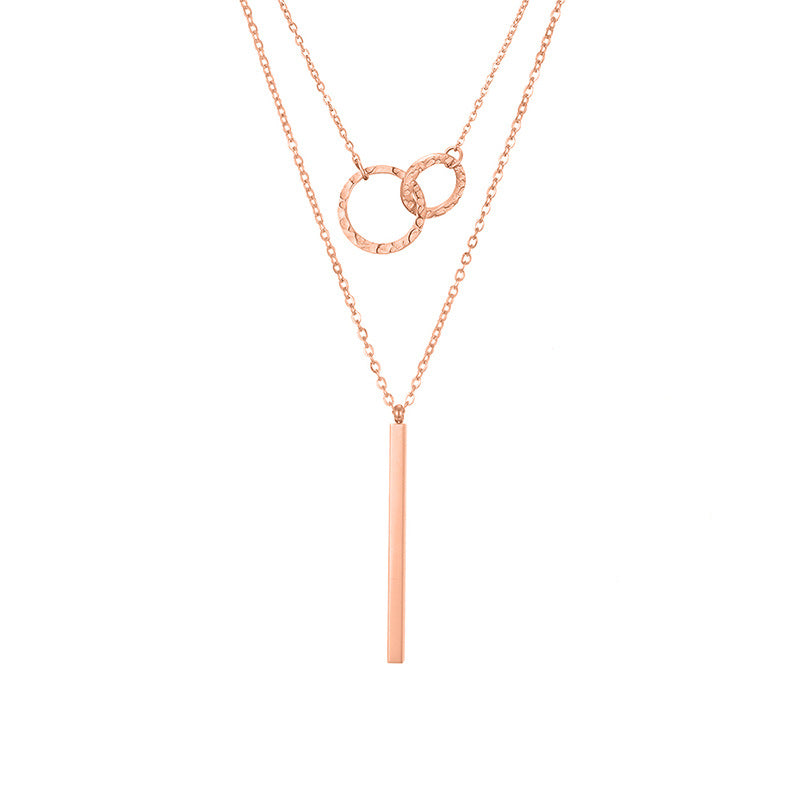 un collier avec une longue barre et deux cercles entrelacés dessus