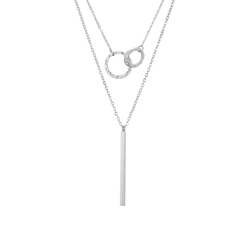 un collier avec une longue barre et un cercle dessus