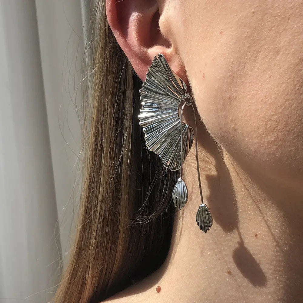 un gros plan d'une personne portant une paire de boucles d'oreilles