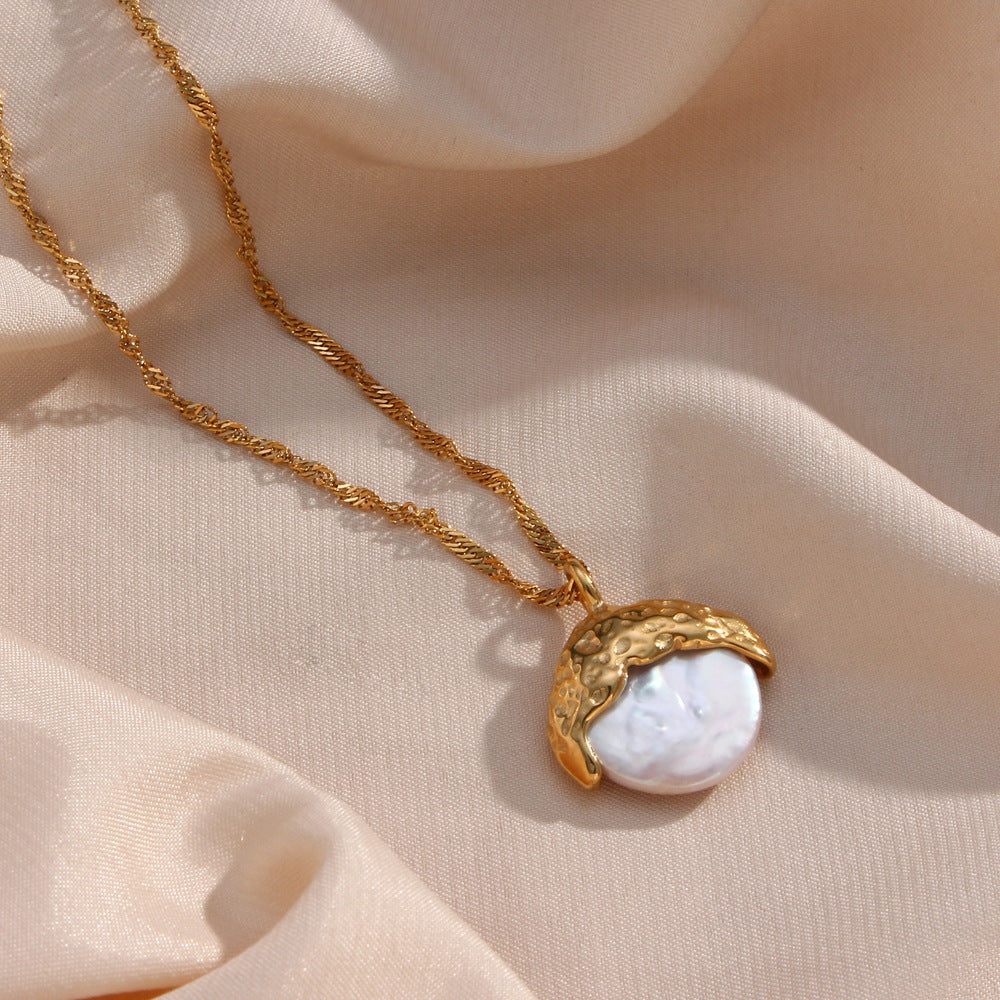 un collier avec une coquille sur une chaîne en or