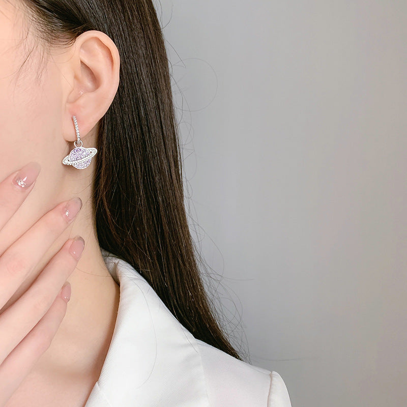 un gros plan d'une personne portant une paire de boucles d'oreilles