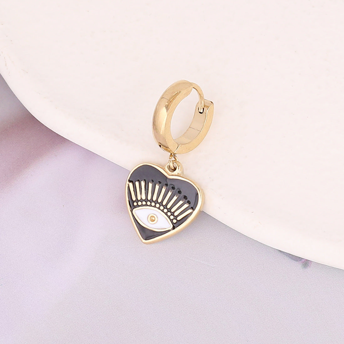 une paire de boucles d'oreilles en or à cerceau avec un design noir et blanc