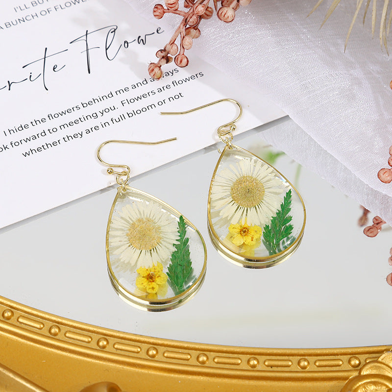 une paire de boucles d'oreilles pissenlit sur une table