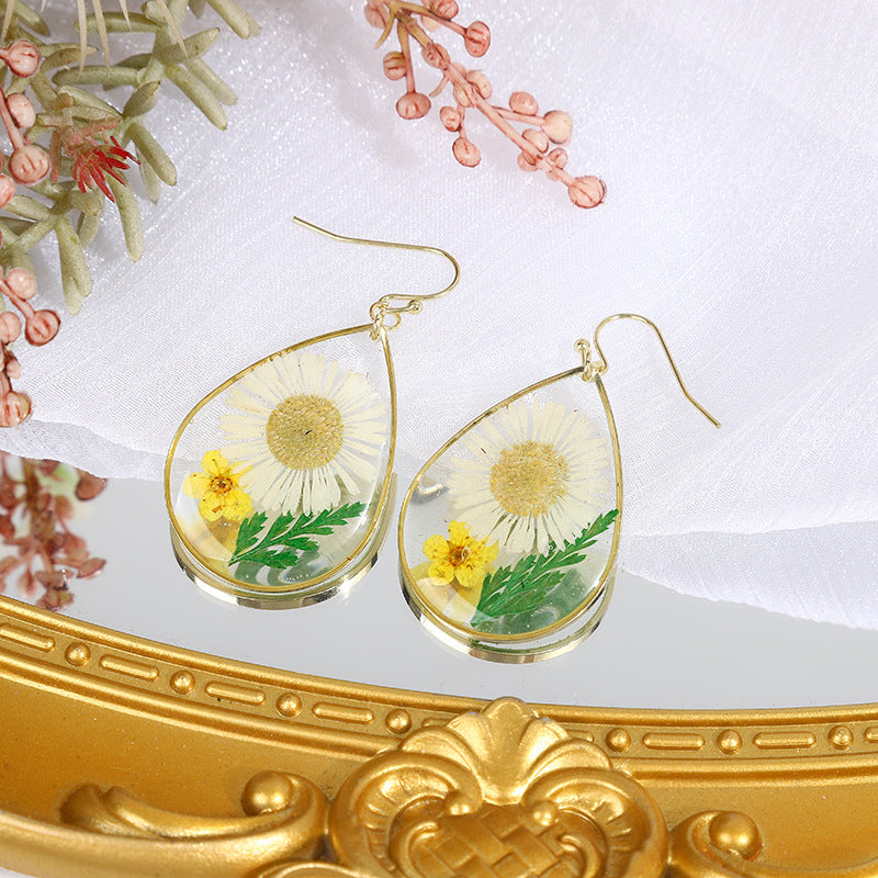 une paire de boucles d'oreilles pissenlit posée sur une table
