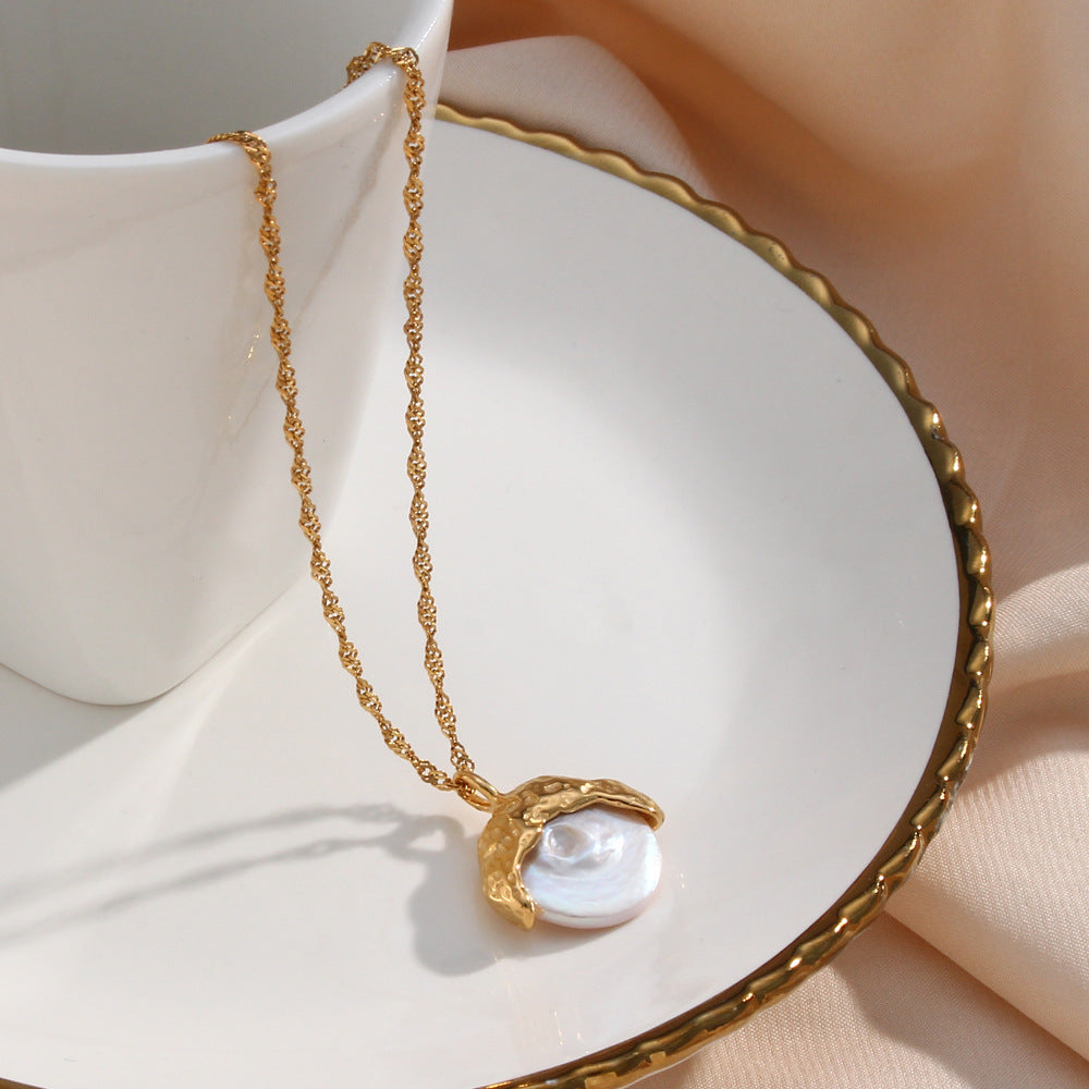 une assiette blanche surmontée d'une chaîne en or et d'une tasse blanche