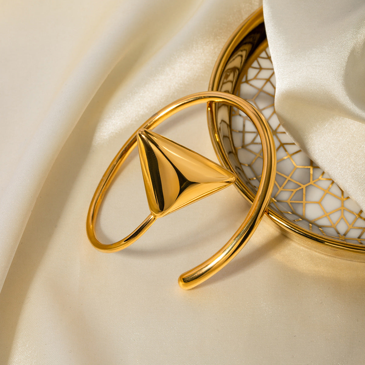 un gros plan sur une bague en or sur un tissu blanc