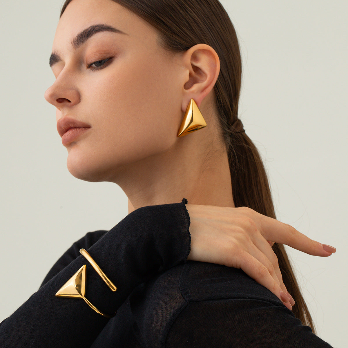 une femme portant une paire de boucles d'oreilles en or