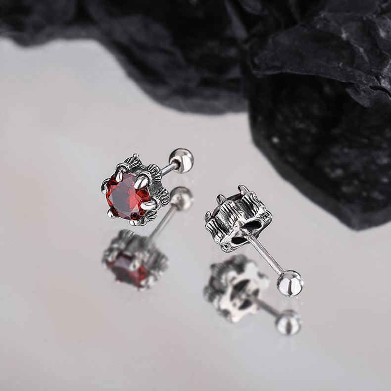 une paire de boucles d'oreilles avec une pierre rouge