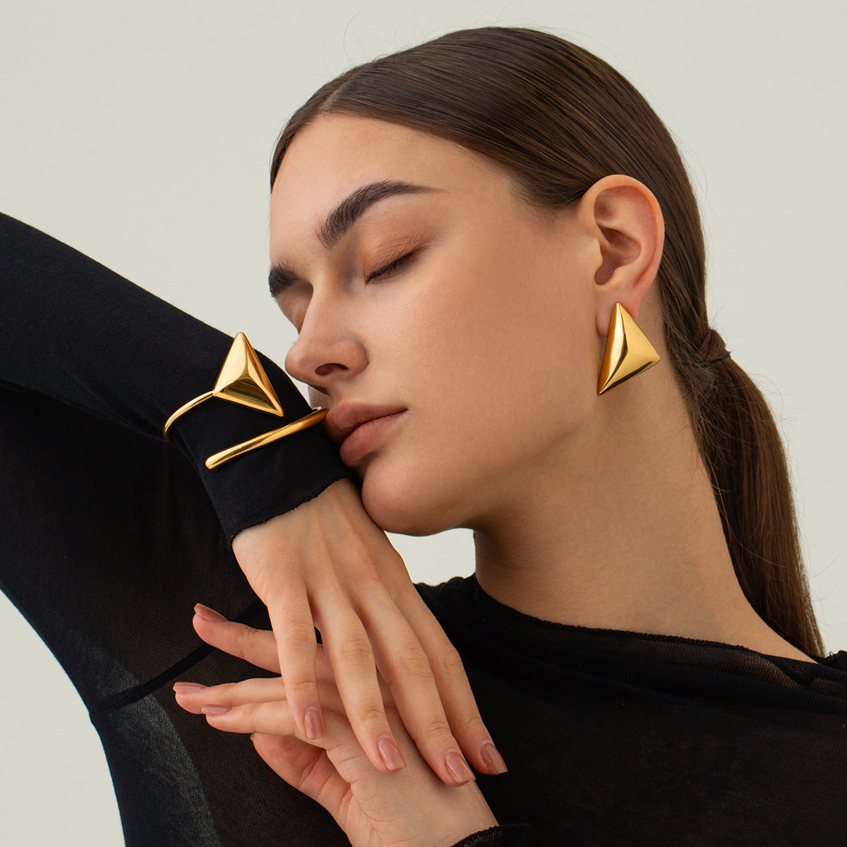une femme portant un haut noir et des boucles d'oreilles en or