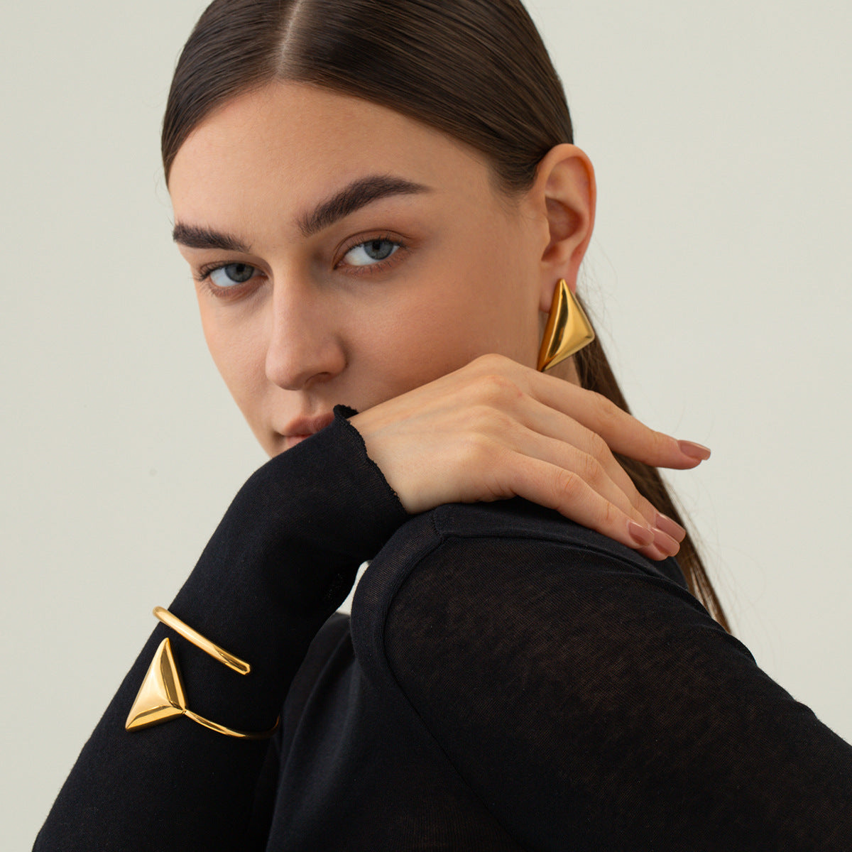 une femme portant un haut noir et des boucles d'oreilles en or