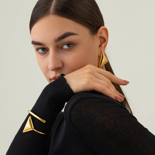 une femme portant un haut noir et des boucles d'oreilles en or