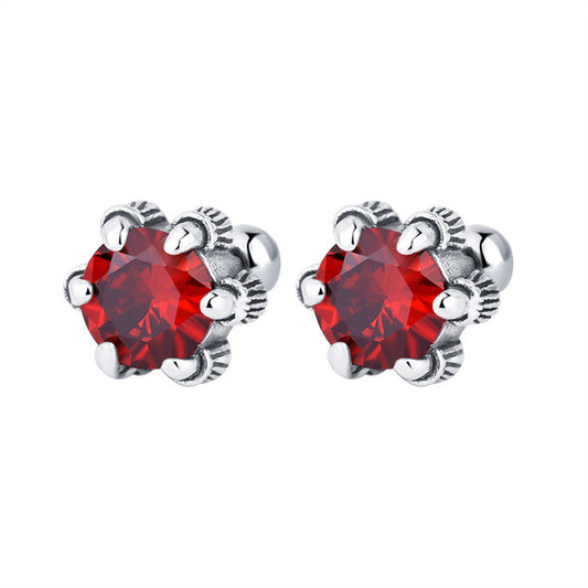 une paire de boucles d'oreilles en cristal rouge sur un fond blanc