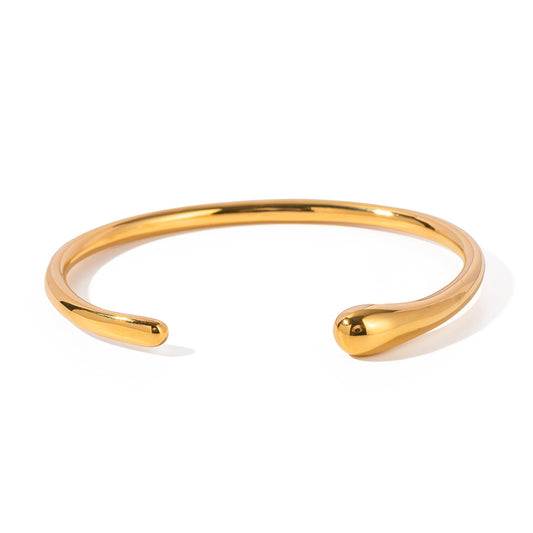 un bracelet manchette en or avec un design courbé