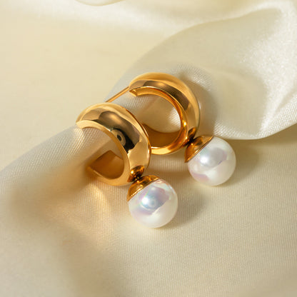 un gros plan d'une paire de boucles d'oreilles sur un tissu blanc