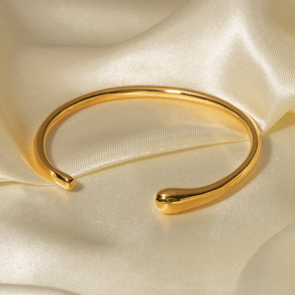 un gros plan d'un bracelet en or sur un tissu blanc