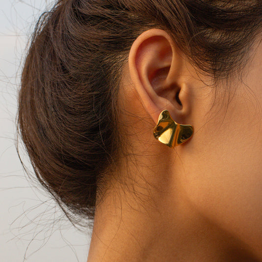 un gros plan d'une personne portant une paire de boucles d'oreilles