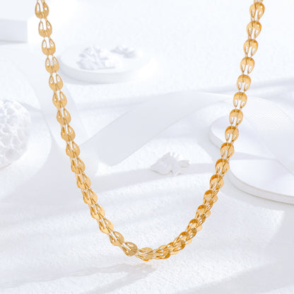 un collier en or sur une surface blanche