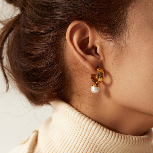 un gros plan d'une personne portant une paire de boucles d'oreilles