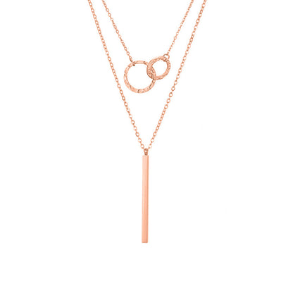 un collier avec une longue barre et deux cercles entrelacés dessus