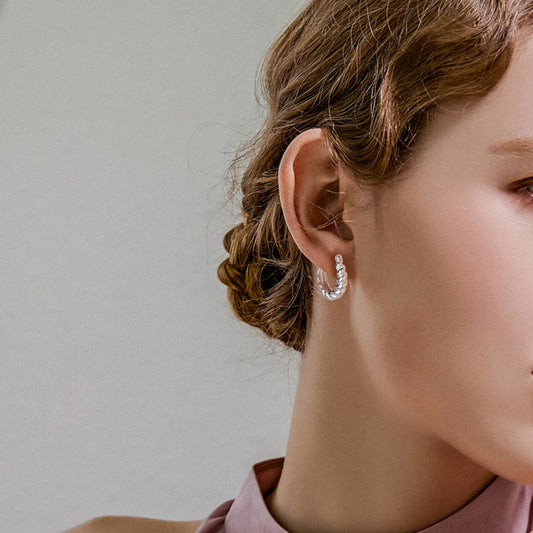 un gros plan d'une personne portant un collier et des boucles d'oreilles