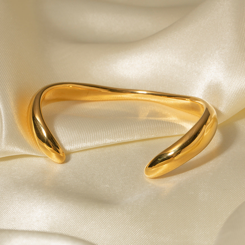 un gros plan d'une bague en or sur un tissu blanc