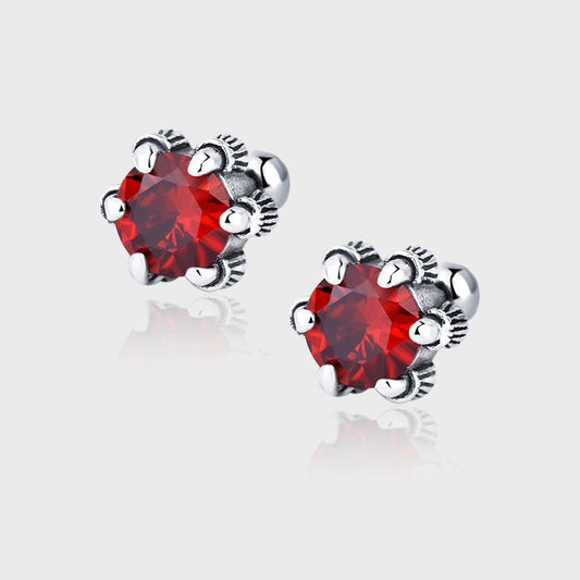 une paire de boucles d'oreilles en cristal rouge sur un fond blanc