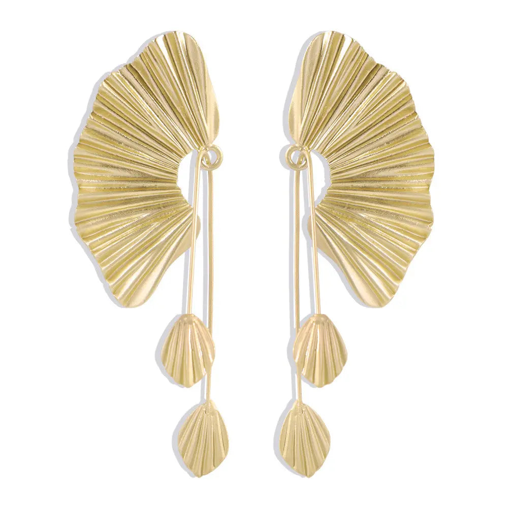 une paire de boucles d'oreilles en or sur un fond blanc