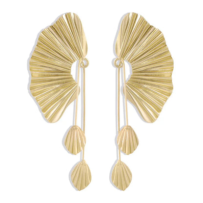 une paire de boucles d'oreilles en or sur un fond blanc