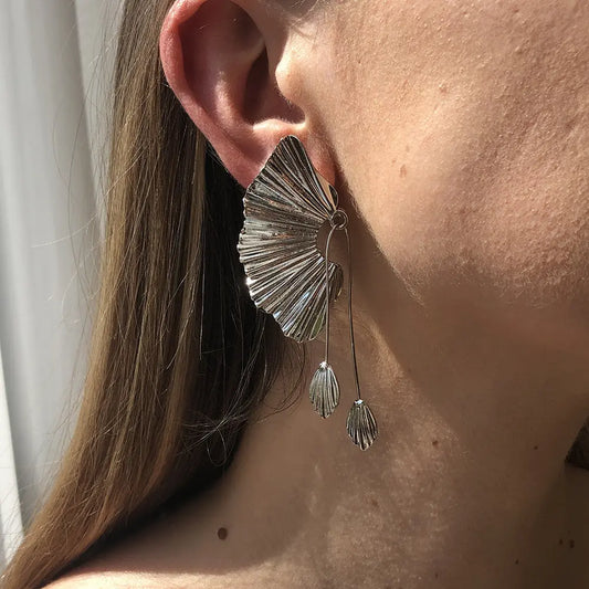 un gros plan d'une personne portant une paire de boucles d'oreilles