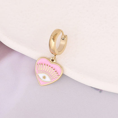 un bijou plaqué or avec un cœur rose et un œil