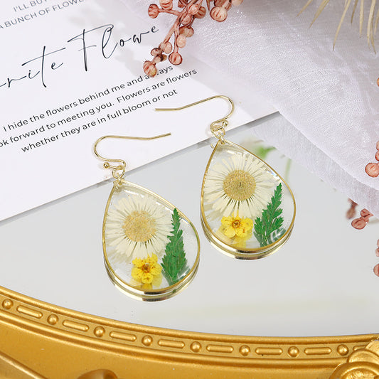 une paire de boucles d'oreilles pissenlit sur une table