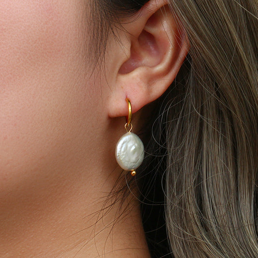 un gros plan d'une personne portant une paire de boucles d'oreilles
