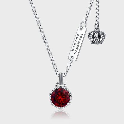 un collier avec une couronne et une pierre rouge