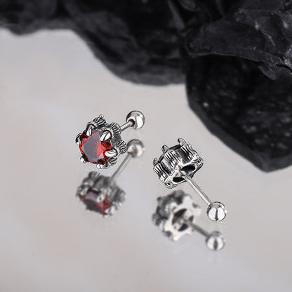 une paire de boucles d'oreilles avec une pierre rouge